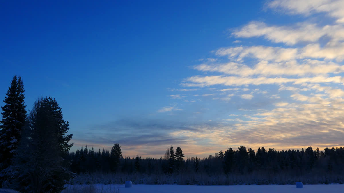 En orangefärgad himmel över ett vinterlandskap.